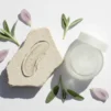 Swatch of light gel moisturiser on a stone surface with green leaves
